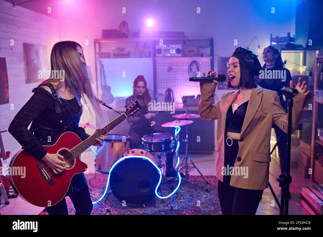 Music female band playing on musical instruments and performing in the night club Stock Photo