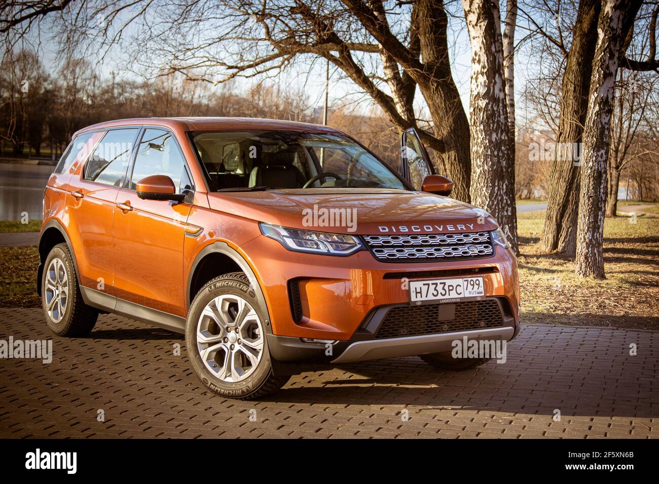Moscow, Russia - December 20, 2019:All new Land Rover Discovery Sport 2020 is parked on the waterfront. Exterior of premium english orange SUV. three quarter front view. All wheel drive car... Stock Photo