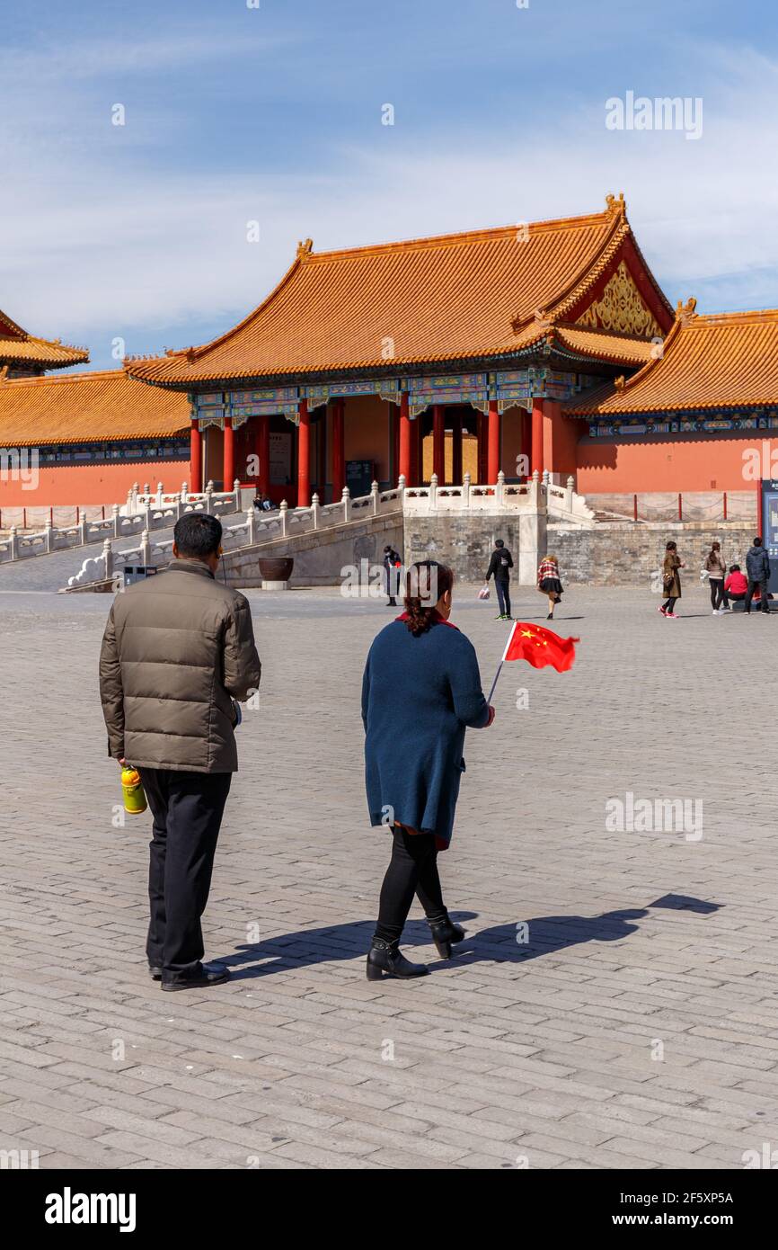Couple with a small Chinese flag at the Forbidden City in Beijing, China in March 2018. Stock Photo