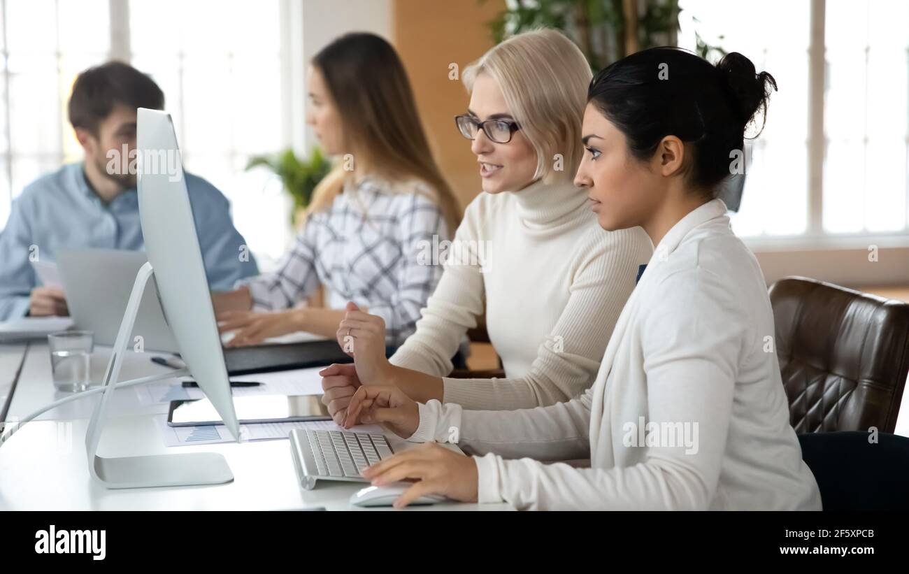 Multiracial female colleagues work on PC in office Stock Photo - Alamy