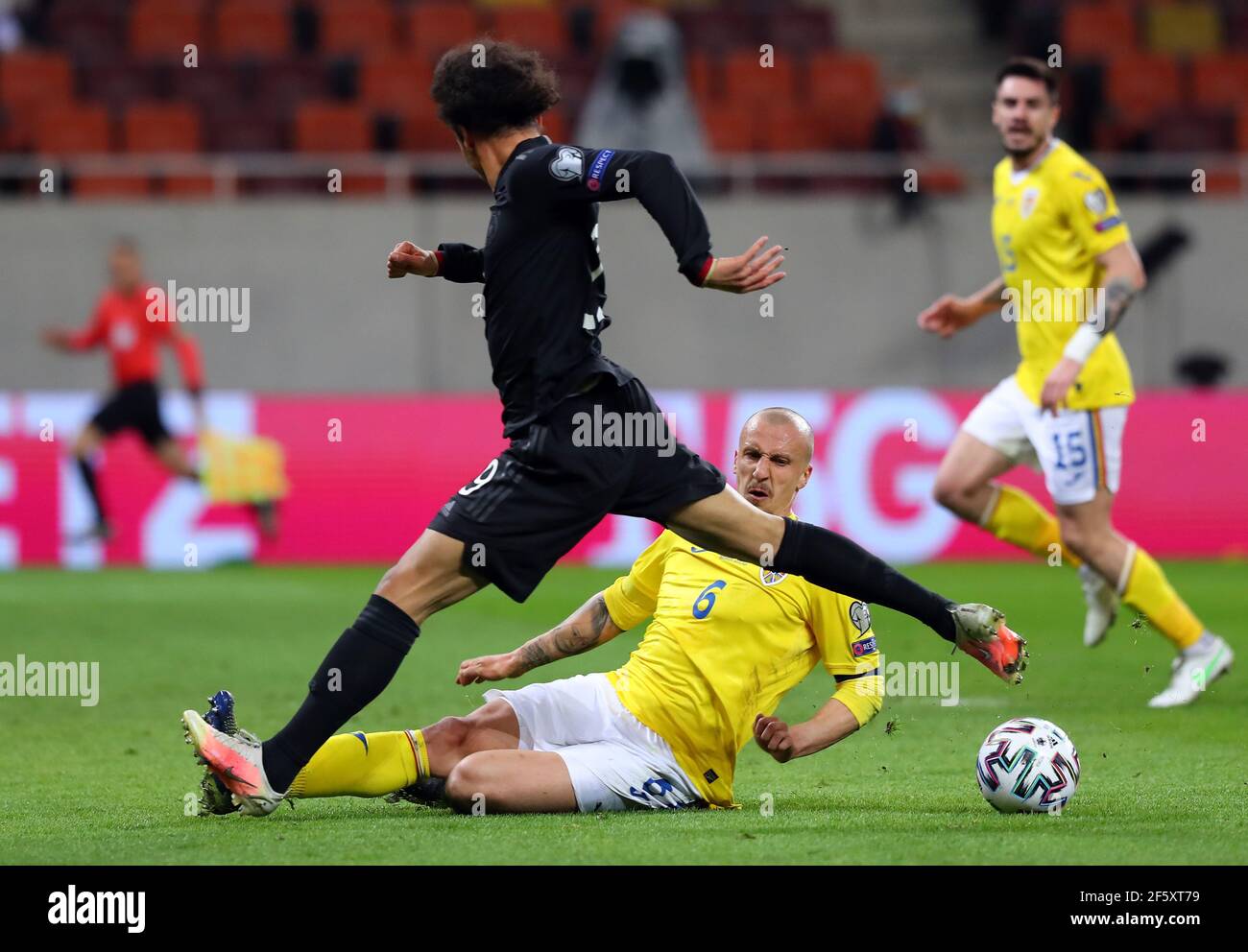 Bukarest, Romania. 28th Mar, 2021. Football: World Cup qualifying Europe, Romania - Germany, Group stage, Group J, Matchday 2 at Arena Nationala. Germany's Leroy Sane and Romania's Vlad Chiriches (u) battle for the ball. IMPORTANT NOTE: In accordance with the regulations of the DFL Deutsche Fußball Liga and the DFB Deutscher Fußball-Bund, it is prohibited to use or have used photographs taken in the stadium and/or of the match in the form of sequence pictures and/or video-like photo series. Credit: Stefan Constantin/dpa/Alamy Live News Stock Photo