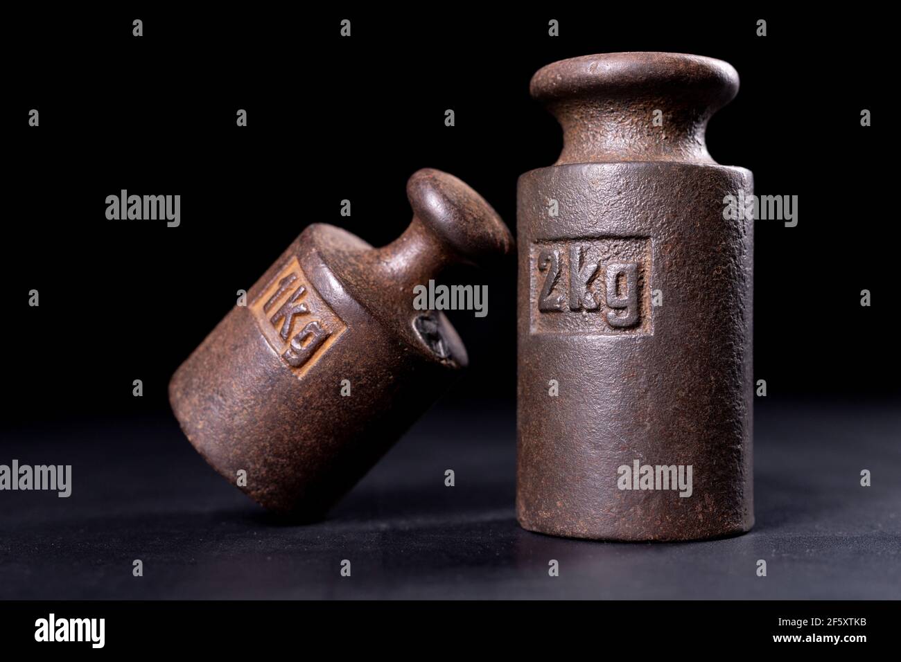 Metal weights for measuring weight. Standard for weighing goods. Dark background. Stock Photo