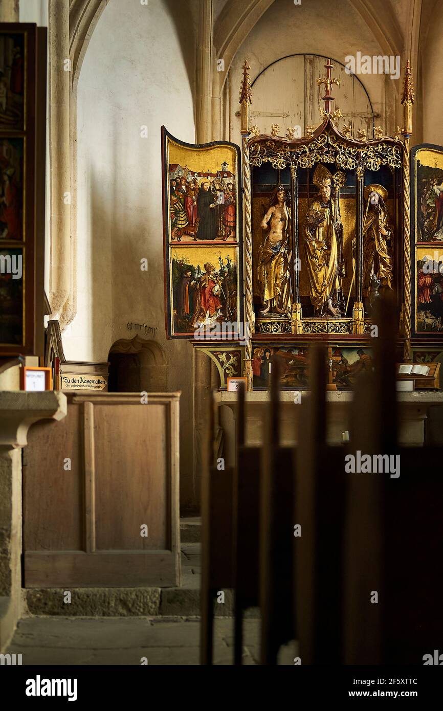 Holy image with golden frame installed on altar behind benches in old