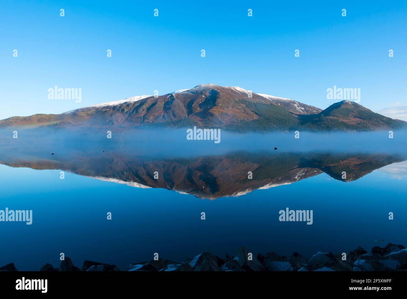Bassenthwaite Lake, on a winter morning. An inversion creates mist above the water, and the still waters offer a mirror image of Skiddaw mountain Stock Photo