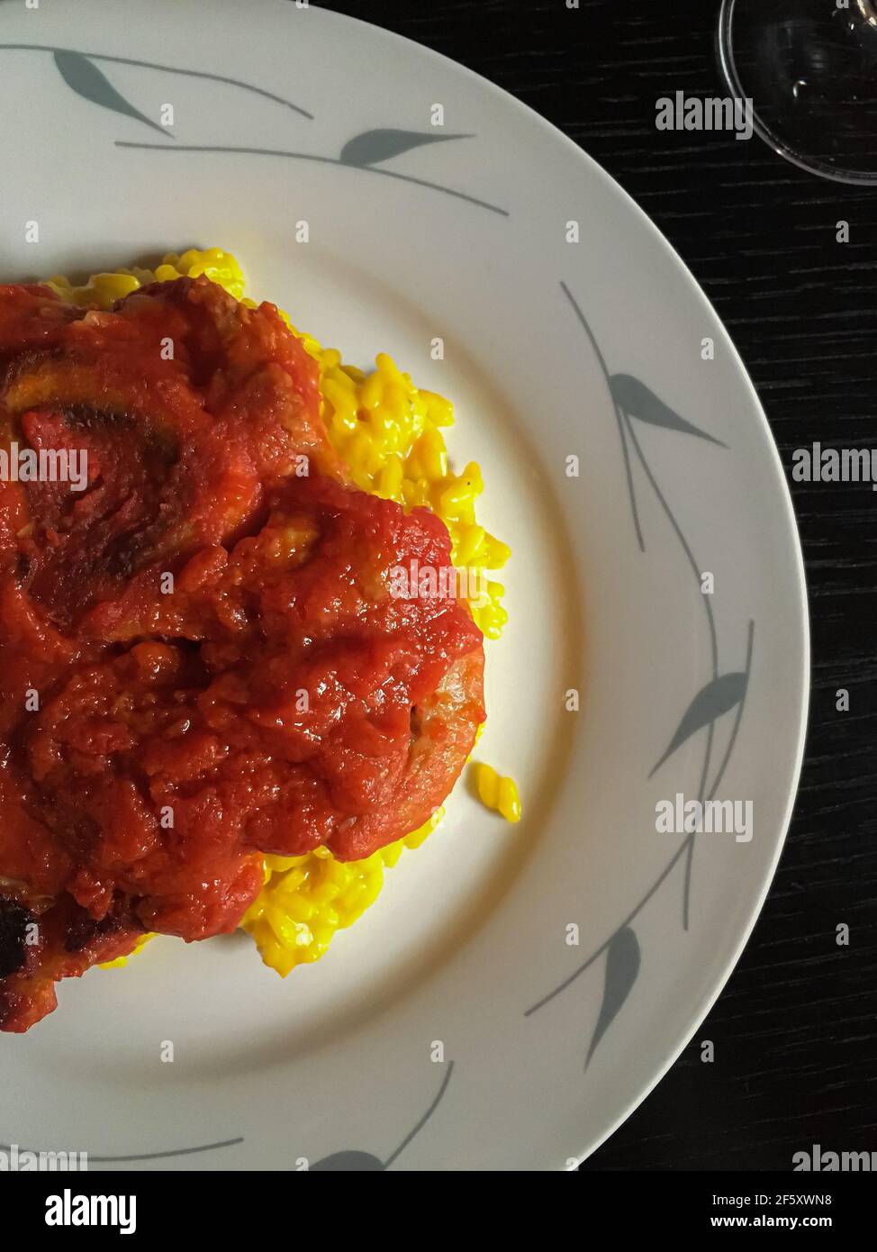 Ossobuco alla Milanese with saffron risotto. Italian cuisine. Traditional and local food. Milan, Lombardy, Italy, Europe. Close-up Stock Photo