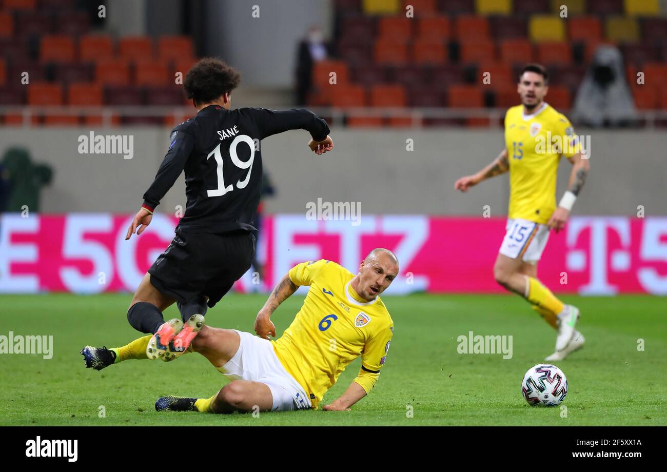 Bukarest, Romania. 28th Mar, 2021. Football: World Cup qualifying Europe, Romania - Germany, Group stage, Group J, Matchday 2 at Arena Nationala. Germany's Leroy Sane and Romania's Vlad Chiriches (u) battle for the ball. IMPORTANT NOTE: In accordance with the regulations of the DFL Deutsche Fußball Liga and the DFB Deutscher Fußball-Bund, it is prohibited to use or have used photographs taken in the stadium and/or of the match in the form of sequence pictures and/or video-like photo series. Credit: Stefan Constantin/dpa/Alamy Live News Stock Photo