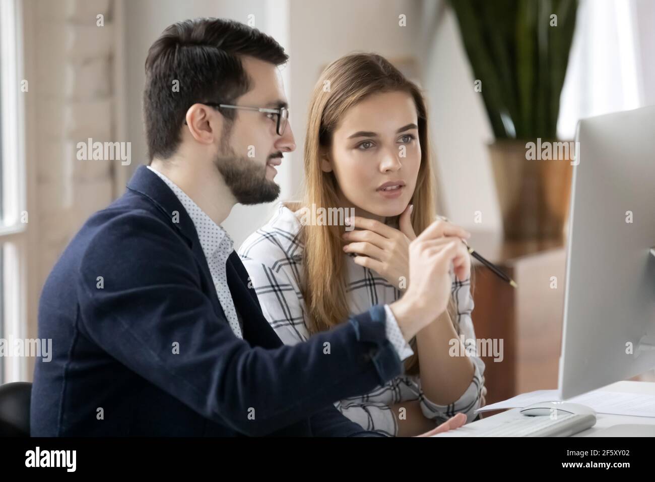 Serious diverse employees work on computer in office Stock Photo