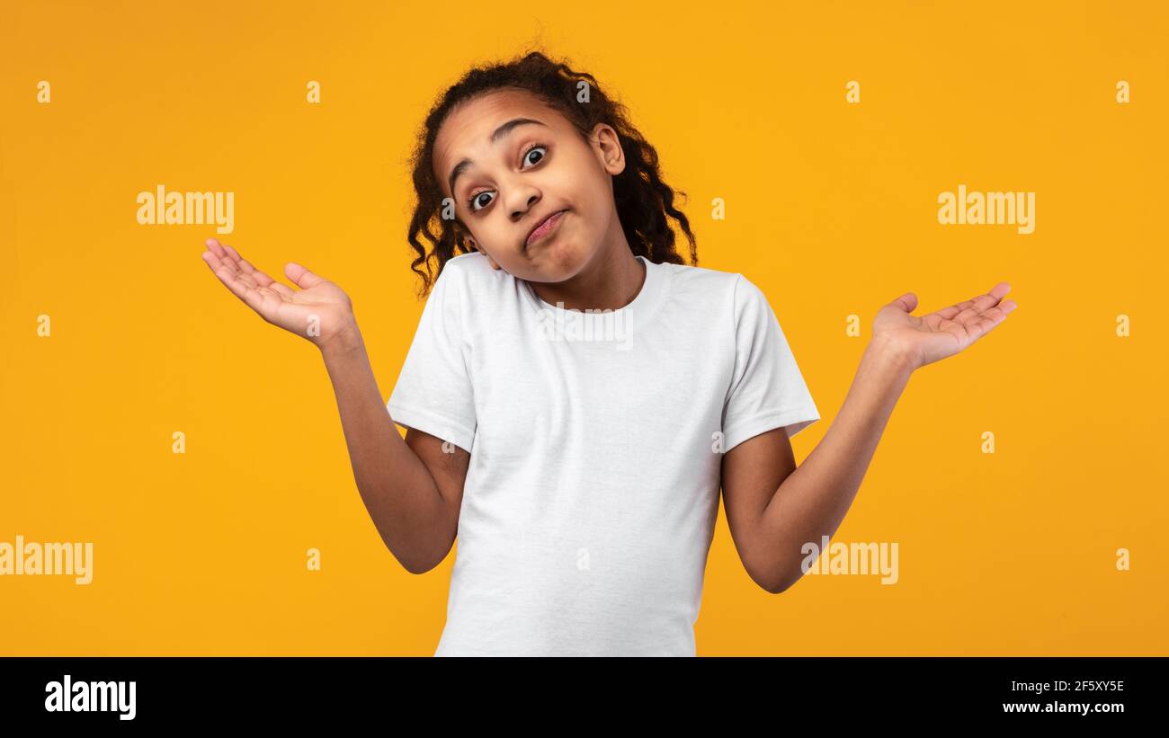 I Don't Know. Confused puzzled black girl shrugging at studio Stock Photo