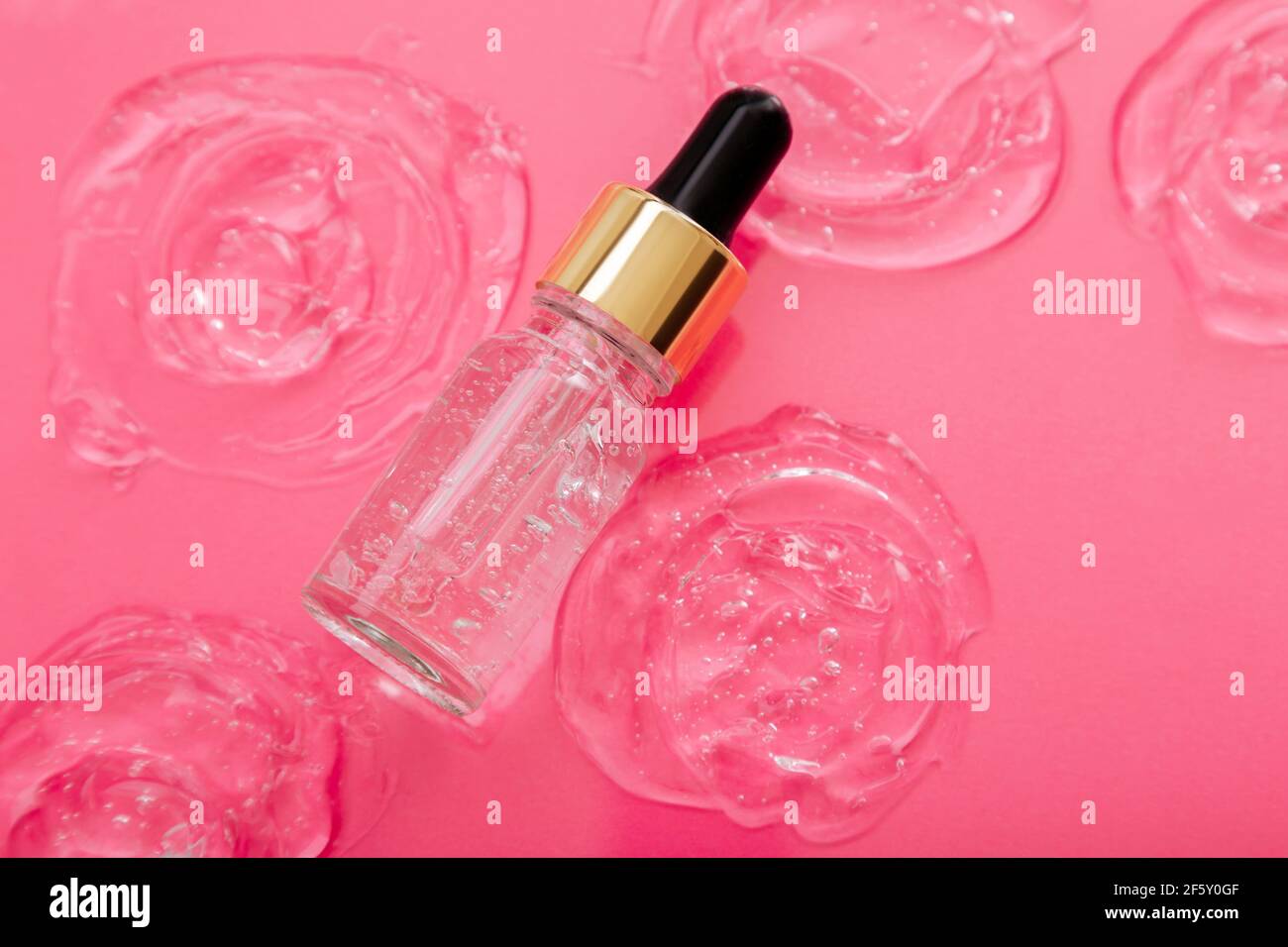 Collagen Serum or hyaluronic serum in dropper on pink color background