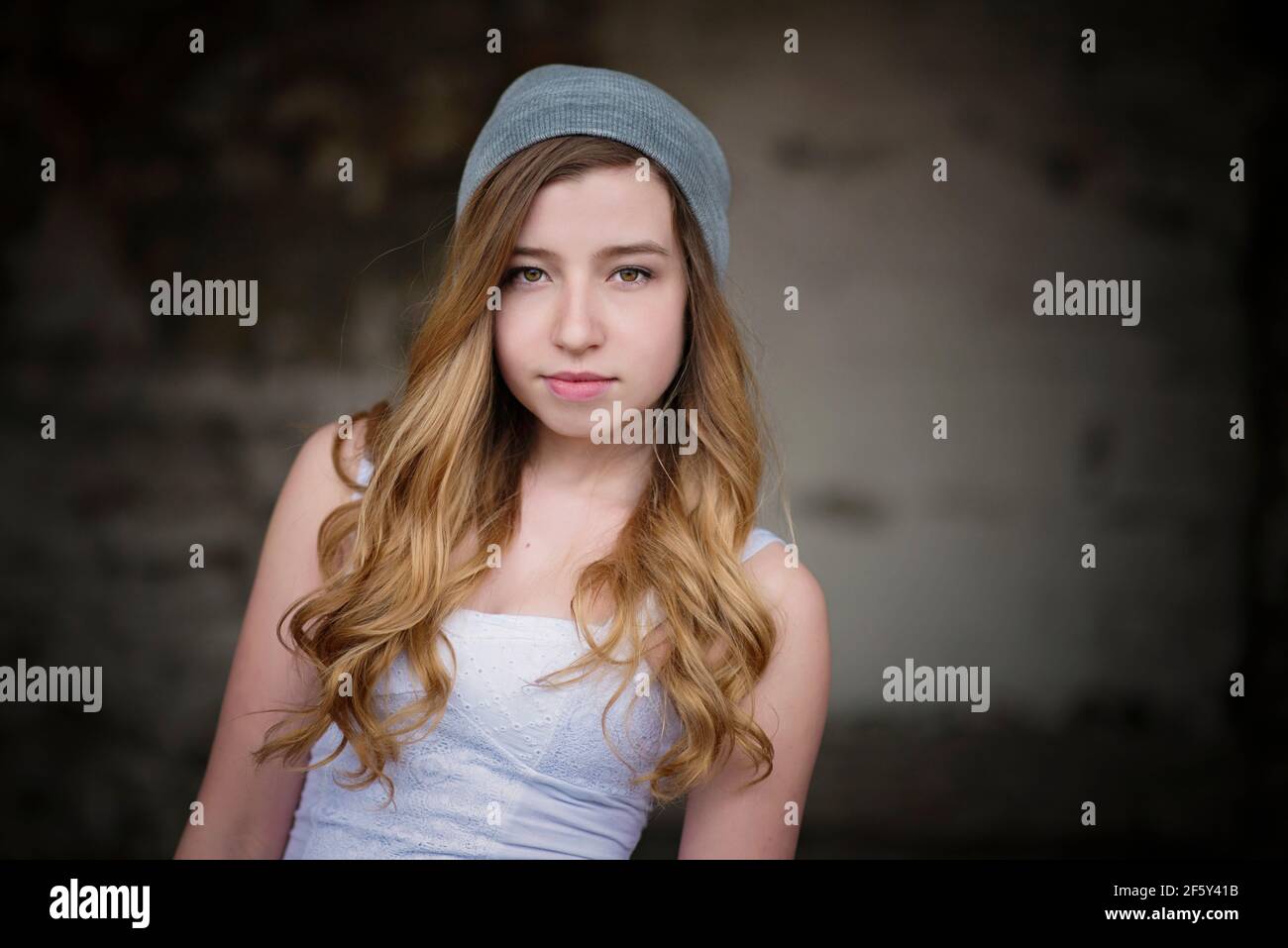 Cool teen girl wearing grey cap in urban setting. Stock Photo