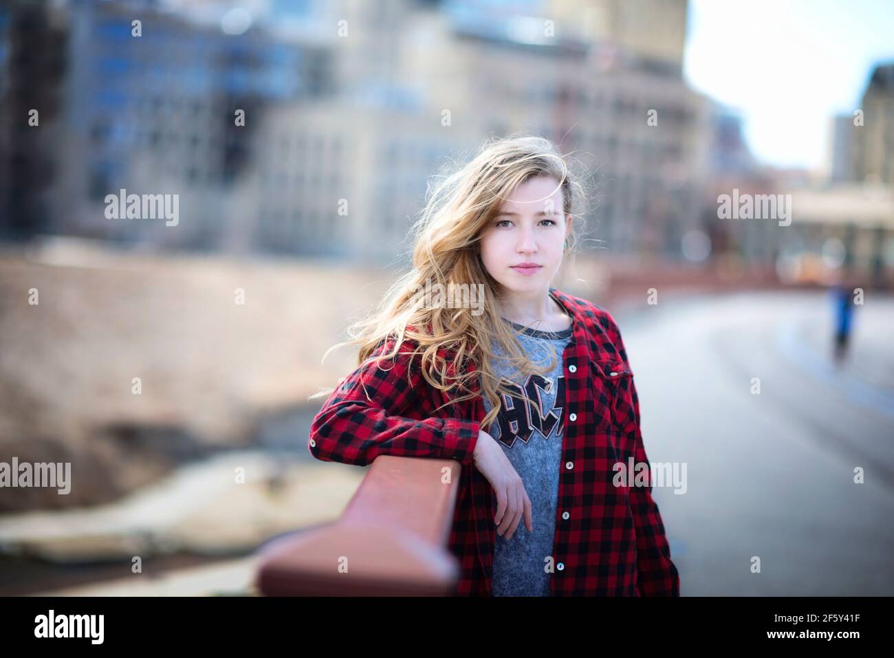 Teen girl with long hair standing in urban setting. Stock Photo