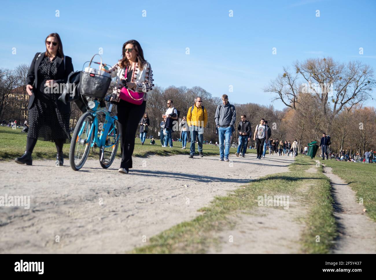 Viele Menschen gehen an einem schönen Sonntag Nachmittag am 28.3.2021 in den Englischen Garten in München. Coronavirus Inzidenz beträgt aktuell 98, 8. Sollte die Inzidenz an drei Tagen über 100 liegen, so tritt die Notbremse in Kraft, so dass die Öffnungen müssen zurückgezogen werden und eine nächtliche Ausgangssperre tritt in Kraft. - Many people on a sunny sunday afternoon go to the English Garten in Munich Germany on March 28. The Covid-19 incidence is 98.8. if it will rise above 100 heavy measures such as a complete lockdown during the night. (Photo by Alexander Pohl/Sipa USA) Stock Photo