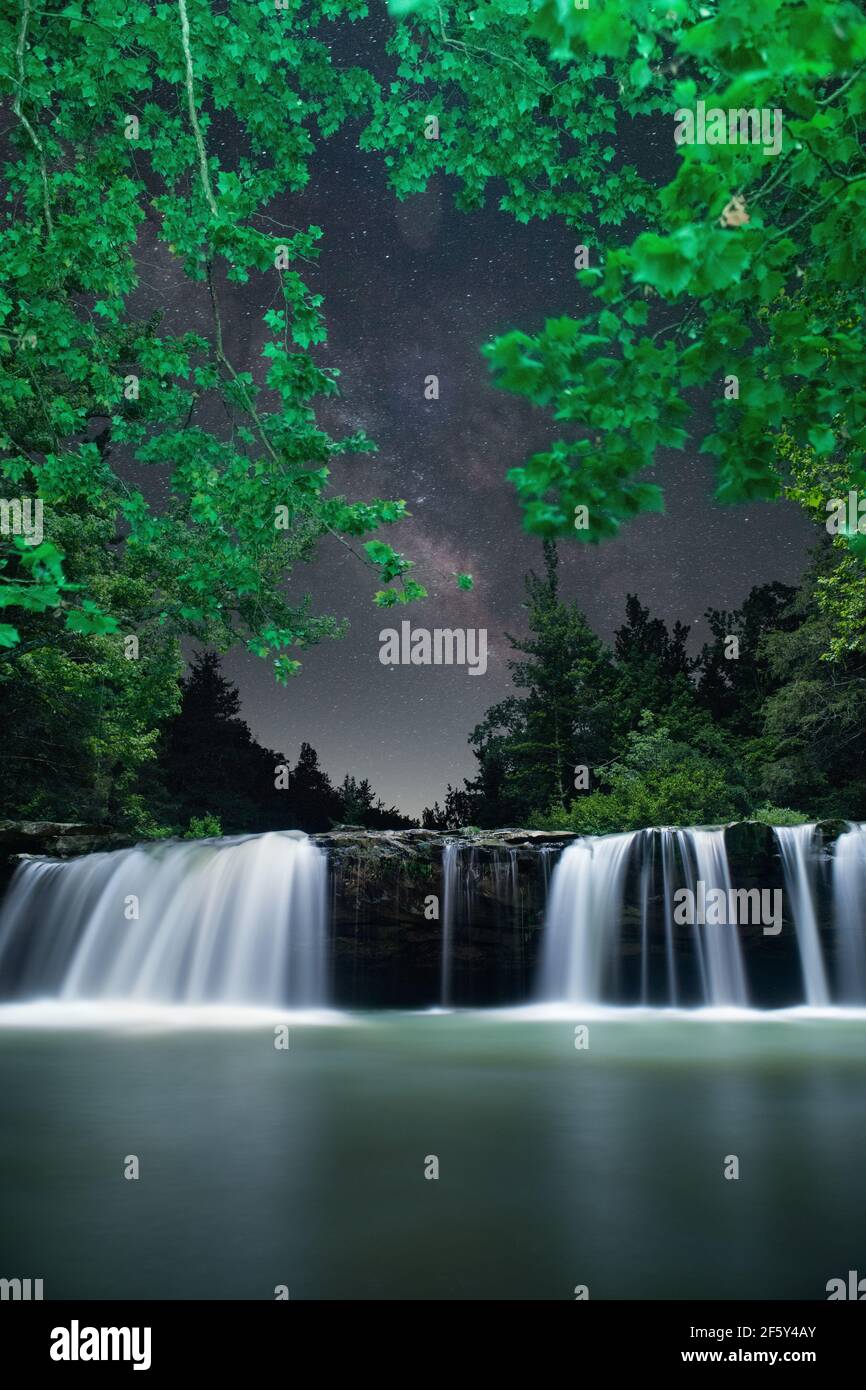 Falling Water Falls Under Sttary Galaxy Night Sky And Trees Stock Photo