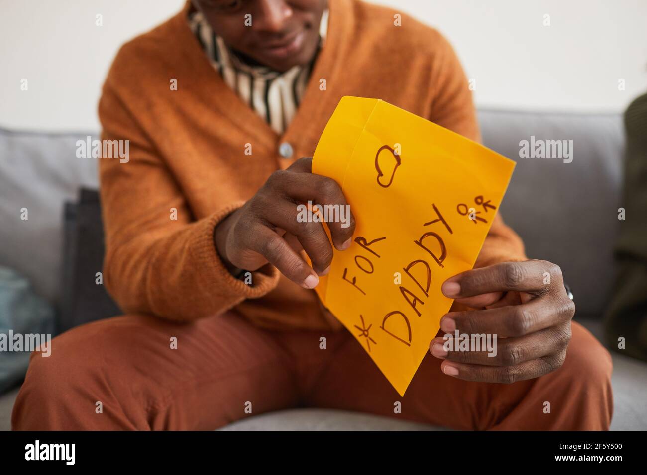 Close up of African-American man opening letter for daddy as handmade gift for Fathers day, copy space Stock Photo
