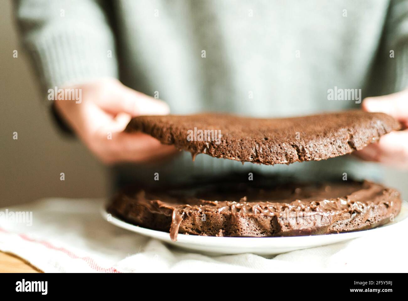 Woman  cooking a chocolate cake in kitchen at home. Stock Photo