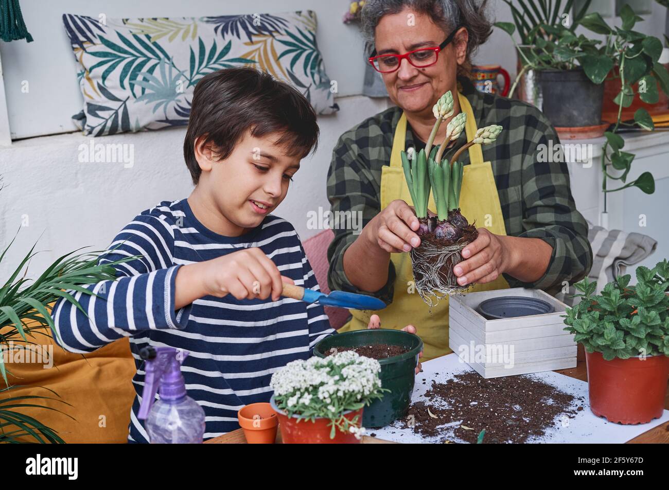 Child Learning With His Mother To Prepare Home Garden Plants In Spring