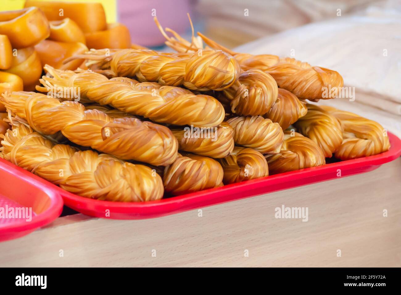 Different smoked cheese on the market counter in summer day. Street cheese trade. Stock Photo