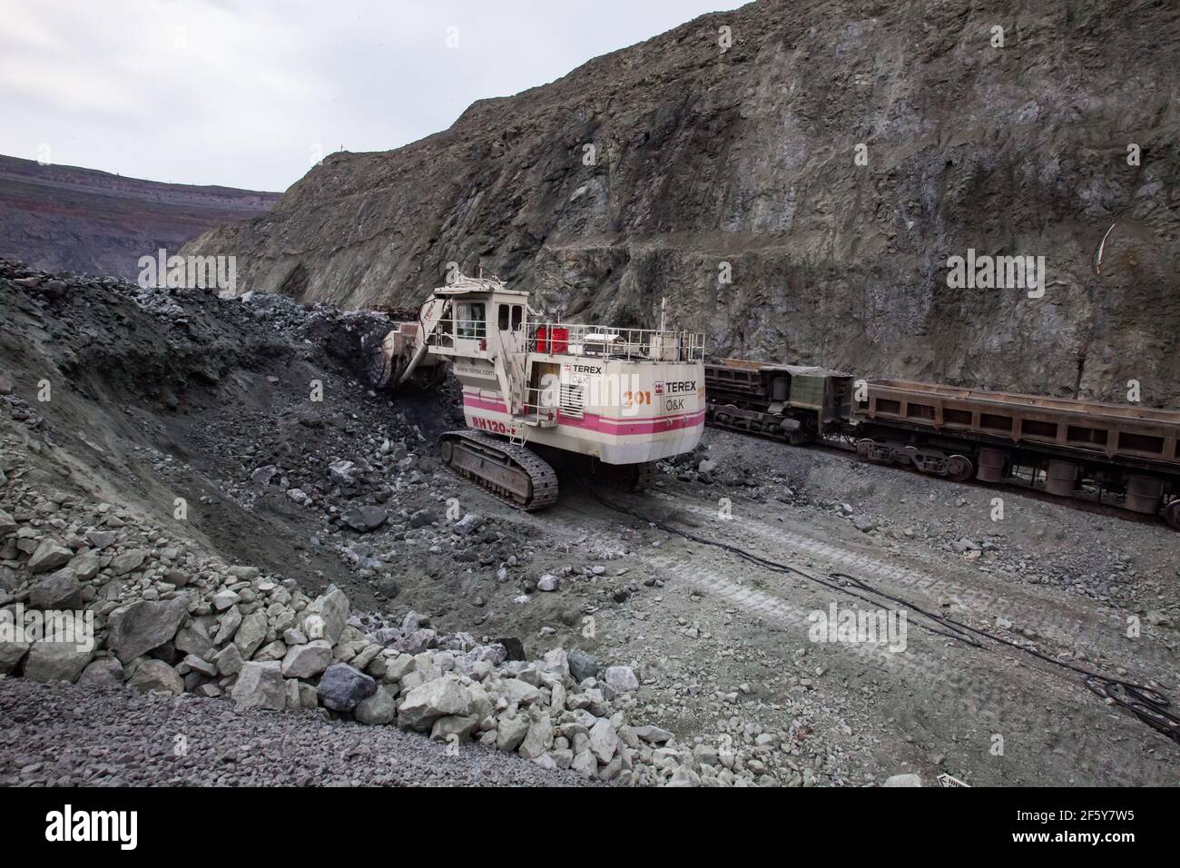 Rudny/Kazakhstan - May 14 2012:  Open-pit mining iron ore in quarry. Excavator Terex loading ore in cargo train wagon. Stock Photo