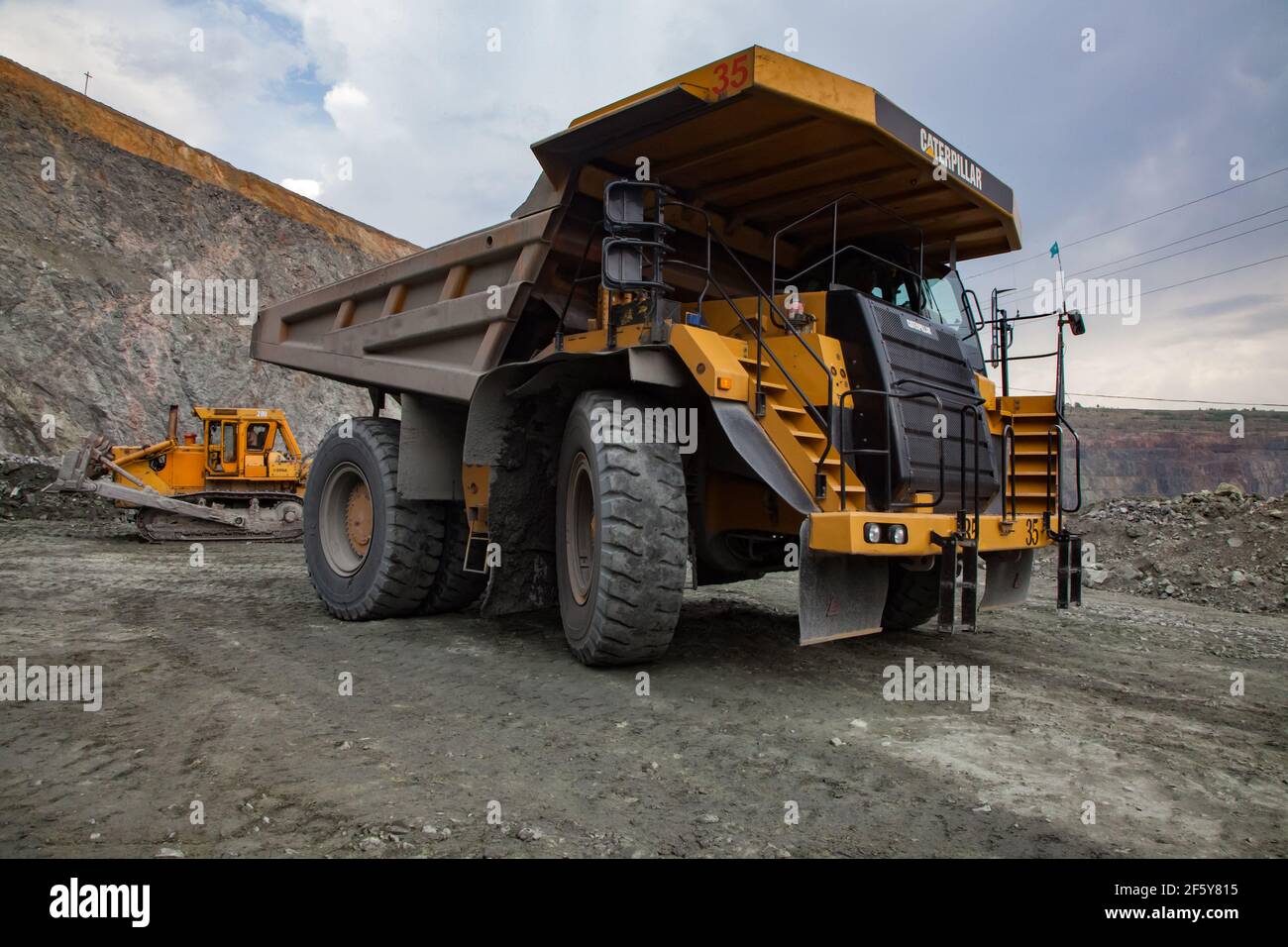Rudny/Kazakhstan - May 14 2012:  Open-pit mining iron ore in quarry. Caterpillar quarry truck transporting ore to concentrating plant. Stock Photo
