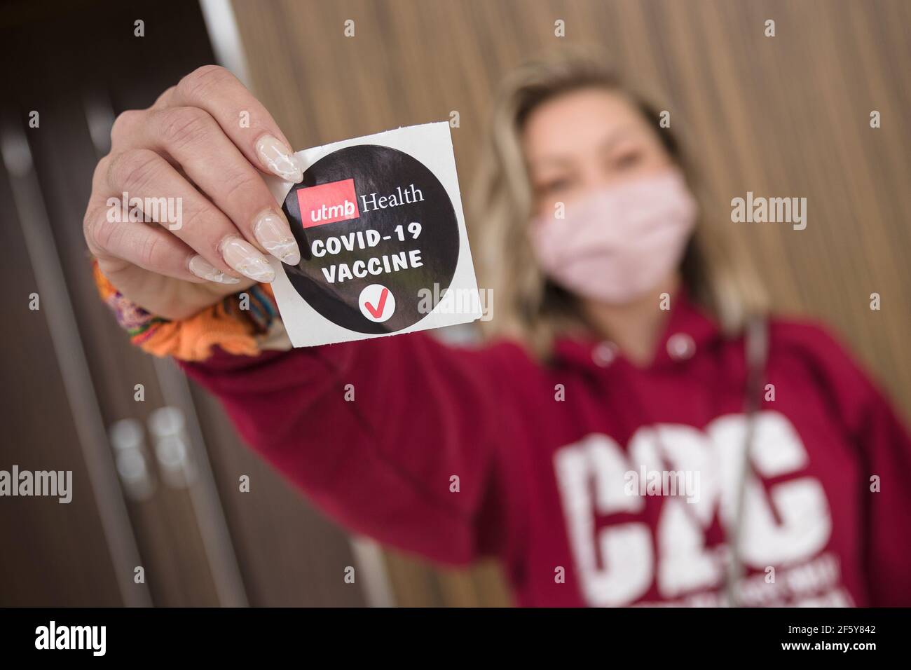 Lake Jackson, Texas, USA. 28th Mar, 2021. A patient displays a sticker proclaiming her recent COVID-19 inoculation during a mass vaccination event held by the University of Texas Medical Branch (UTMB Health) at Brazosport College in Lake Jackson, Texas. Prentice C. James/CSM/Alamy Live News Stock Photo