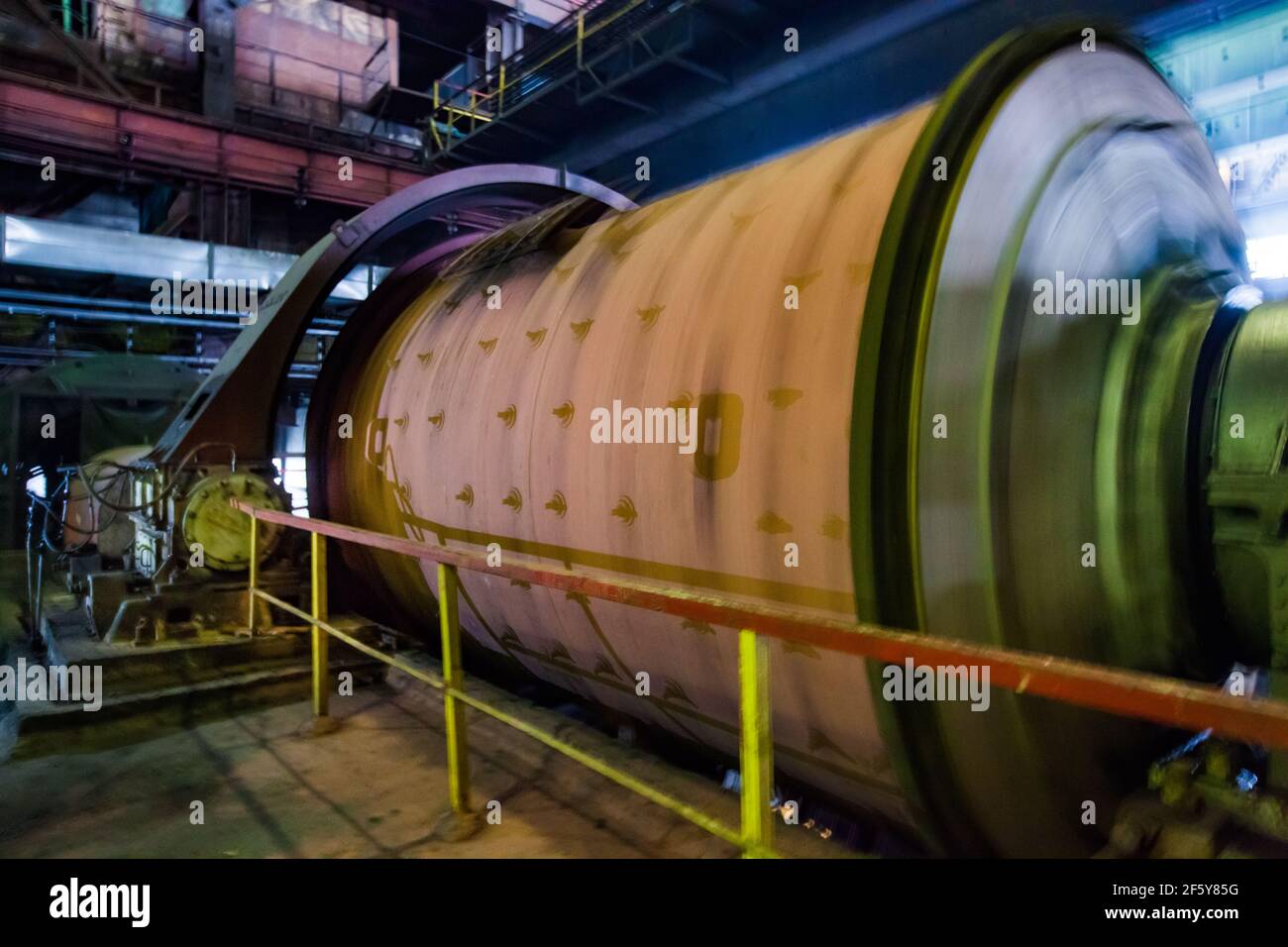Industrial ball mill on the ore concentration plant. Motion blurred rotated drum. Stock Photo