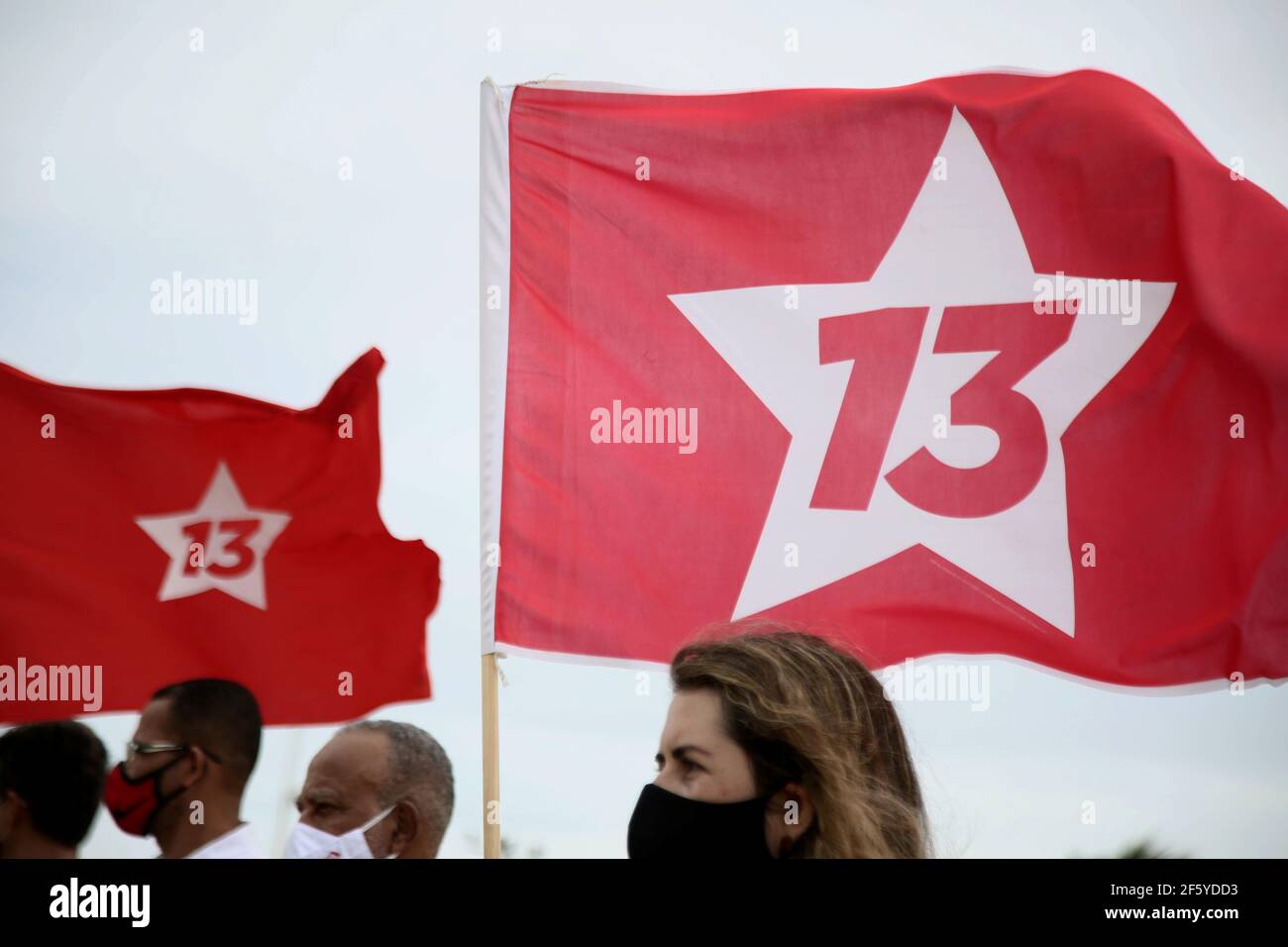 salvador, bahia, brazil - january 22, 2021: militant of Partido dos Trabalhadores - PT, is seen holding the flag of coalition 13 during a demonstratio Stock Photo