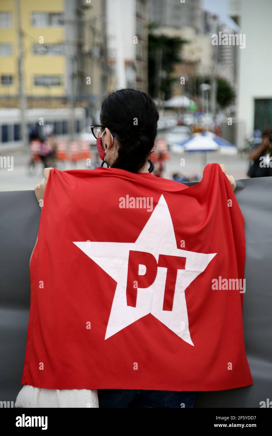 salvador, bahia, brazil - january 22, 2021: militant of Partido dos Trabalhadores - PT, is seen holding the flag of coalition 13 during a demonstratio Stock Photo