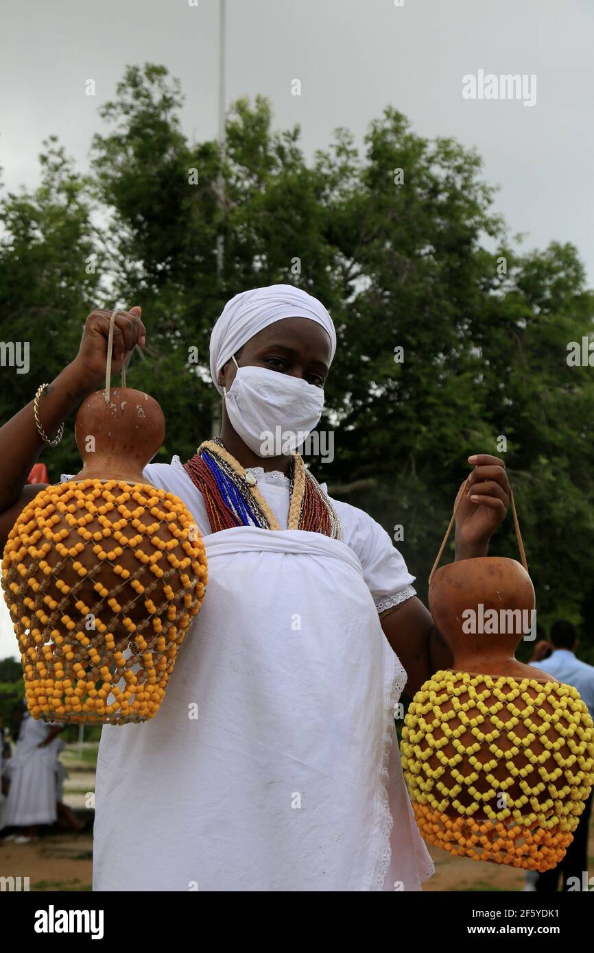 salvador, bahia, brazil - january 6, 2021: adept of candomble holds the xequere, also known as abe e agbe, a percussion musical instrument made of gou Stock Photo