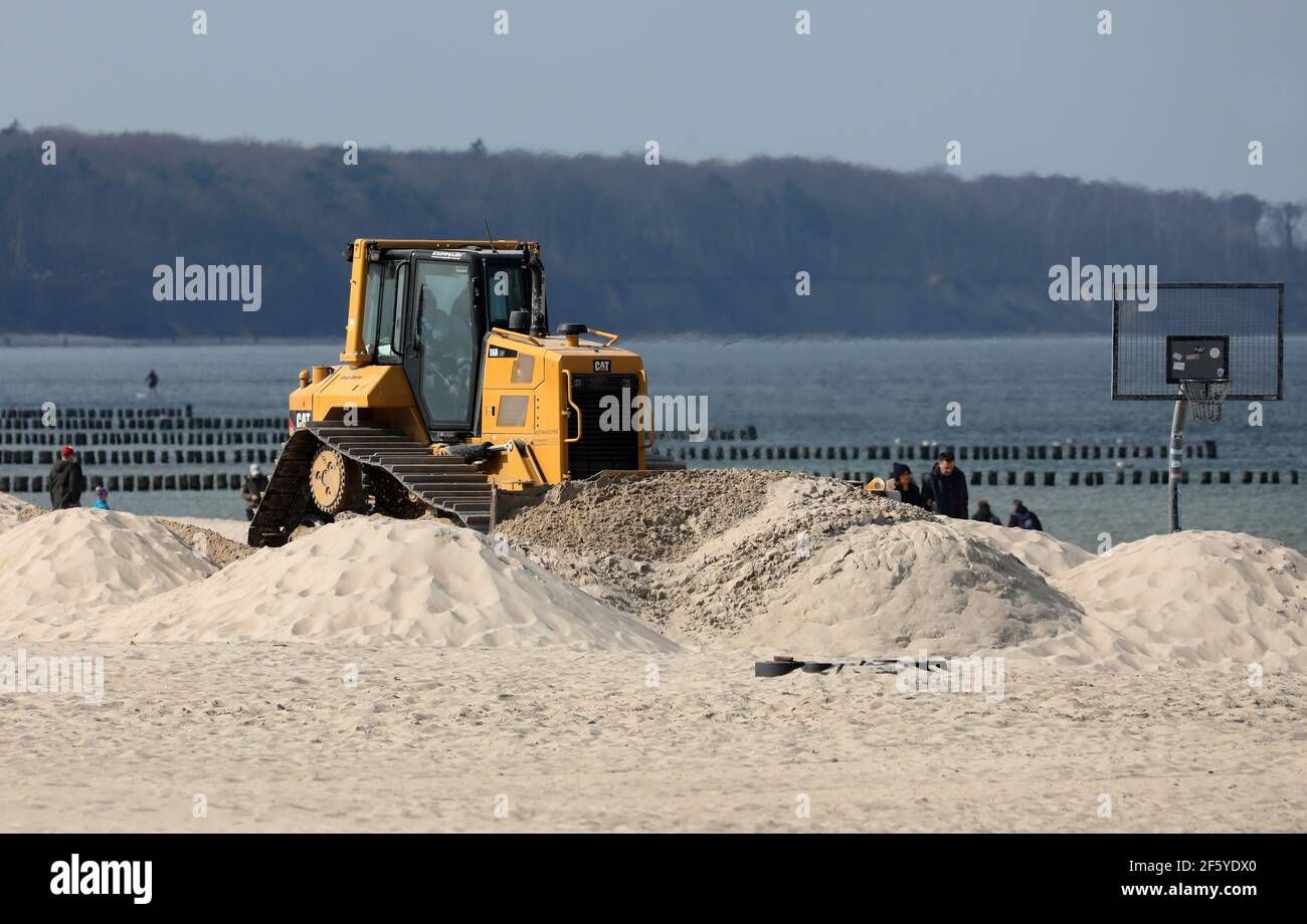 26 March 2021, Mecklenburg-Western Pomerania, Warnemünde: A bulldozer  levels the Baltic Sea beach. The State Office for Agriculture and the  Environment StALU has stopped the first seasonal preparations of beach  chair renters.