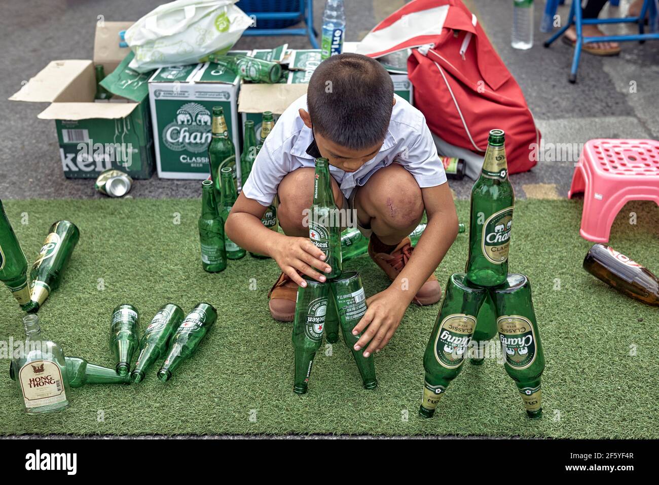 Imaginative child. Young boy arranging and balancing beer bottles trick