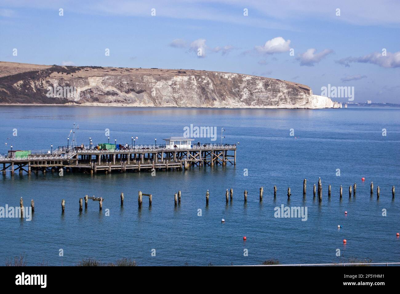 View across Swanage Bay, Dorset on a sunny spring morning with the old and new piers jutting into the sea. Stock Photo
