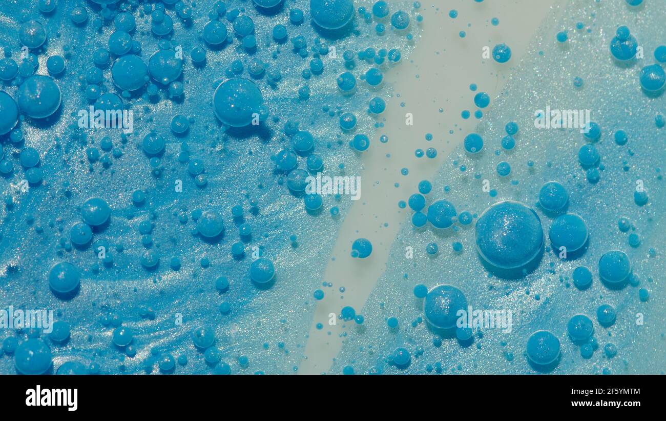 Top view movement of blue oil ink drops bubbles, multicolored artistic ...