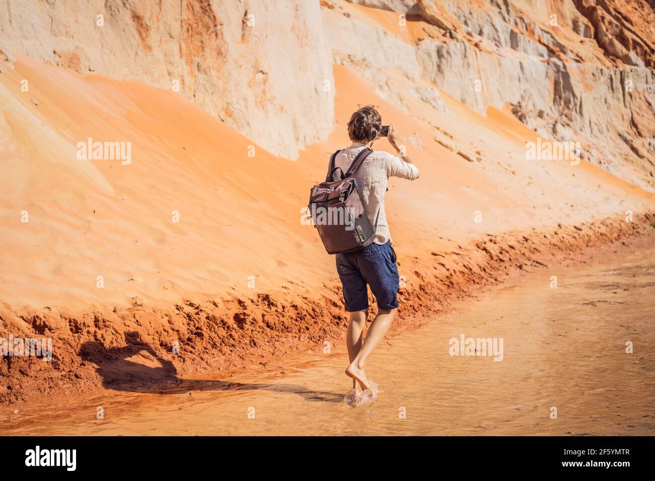 Man tourist on the Fairy stream among the red dunes, Muine, Vietnam. Vietnam opens borders after quarantine COVID 19 Stock Photo