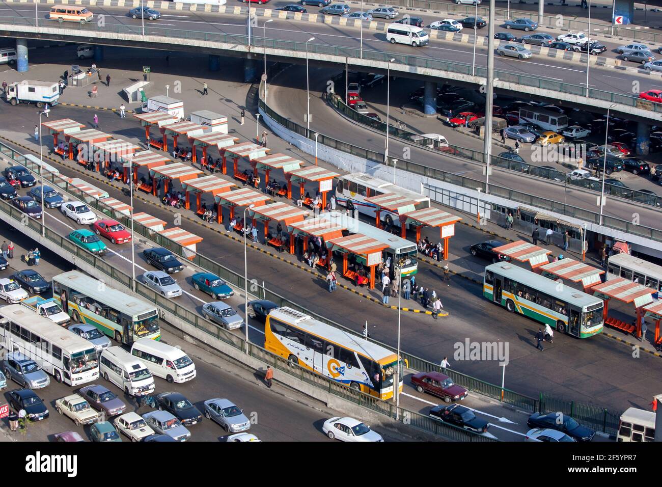 Traffic comes to a crawl on the roads of downtown Cairo in Egypt in the late afternoon. In the centre stands a bus station. Stock Photo