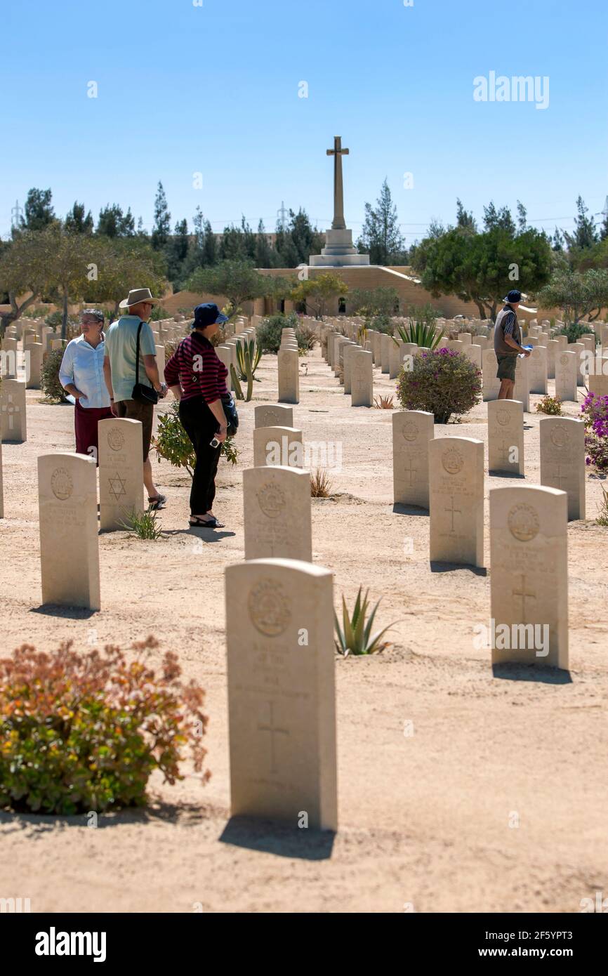 Tourists inspect Commonwealth war graves at El Alamein War Cemetery in northern Egypt. The cemetery contains the graves of British Empire soldiers. Stock Photo