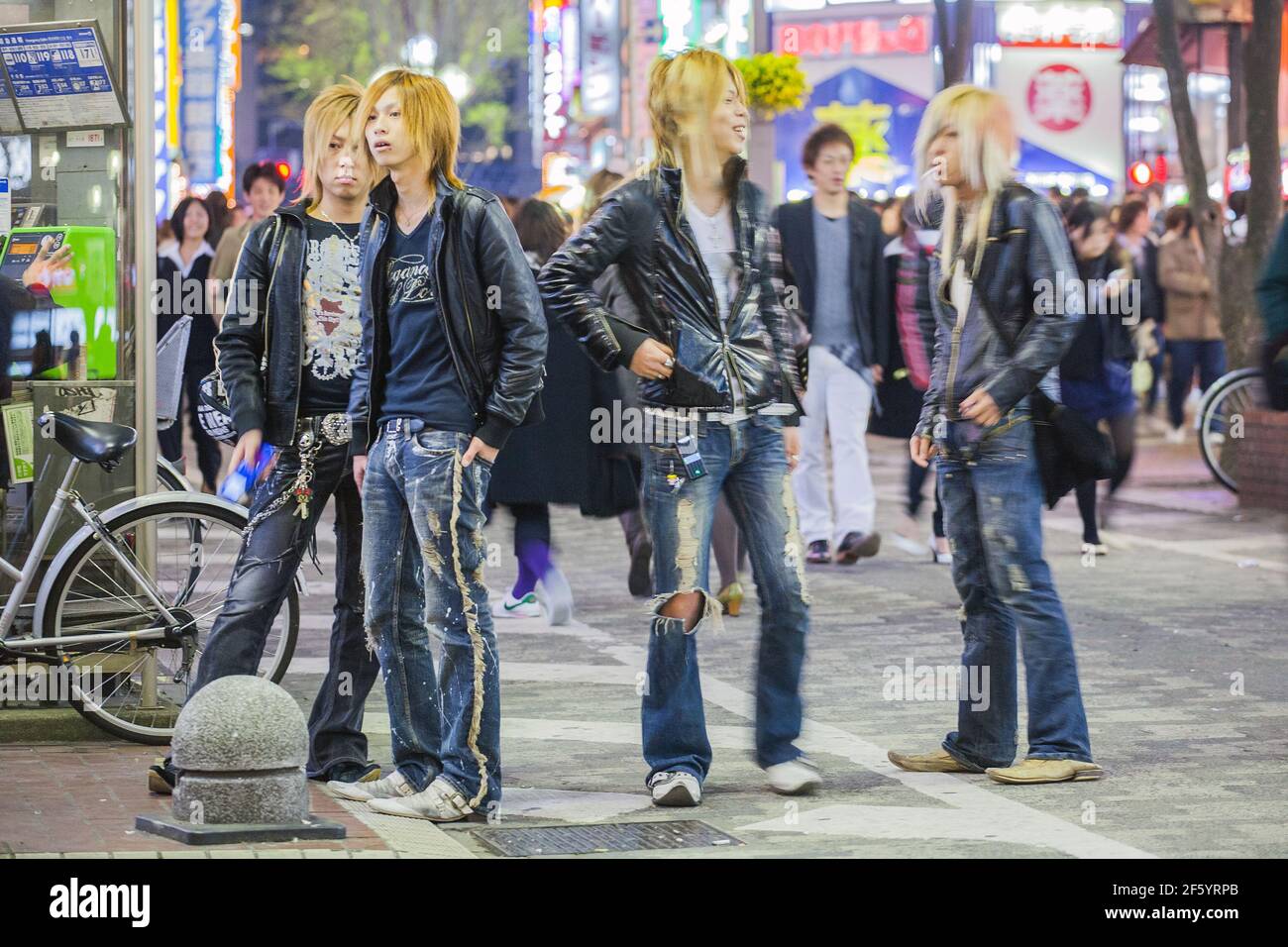 Japanese male hosts looking like rock'n'rollers with big hair and ripped jeans touting for business on the streets of Shinjuku, Tokyo, Japan Stock Photo