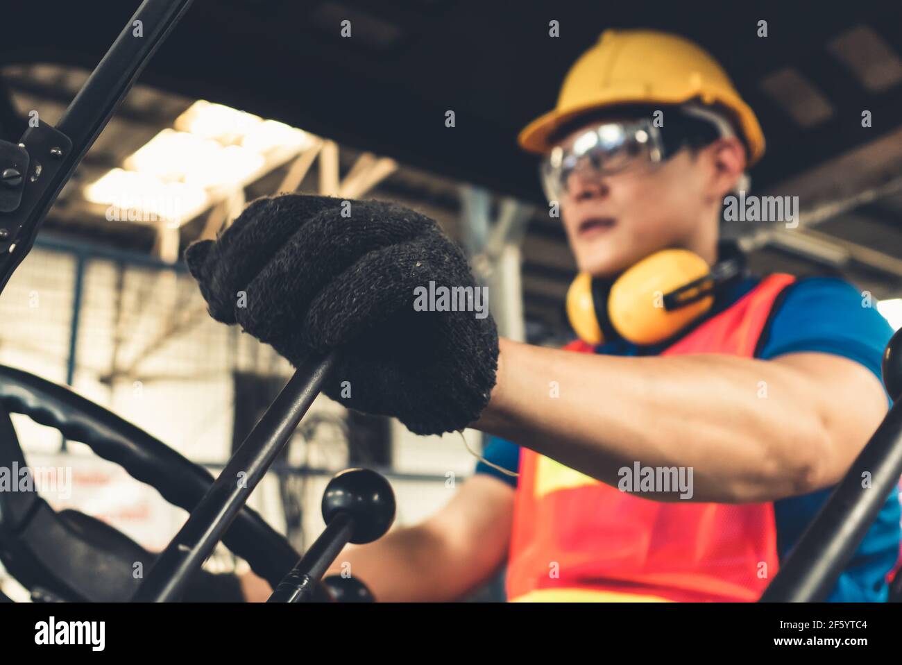 Skillful worker drives forklift in the factory . Industrial people and