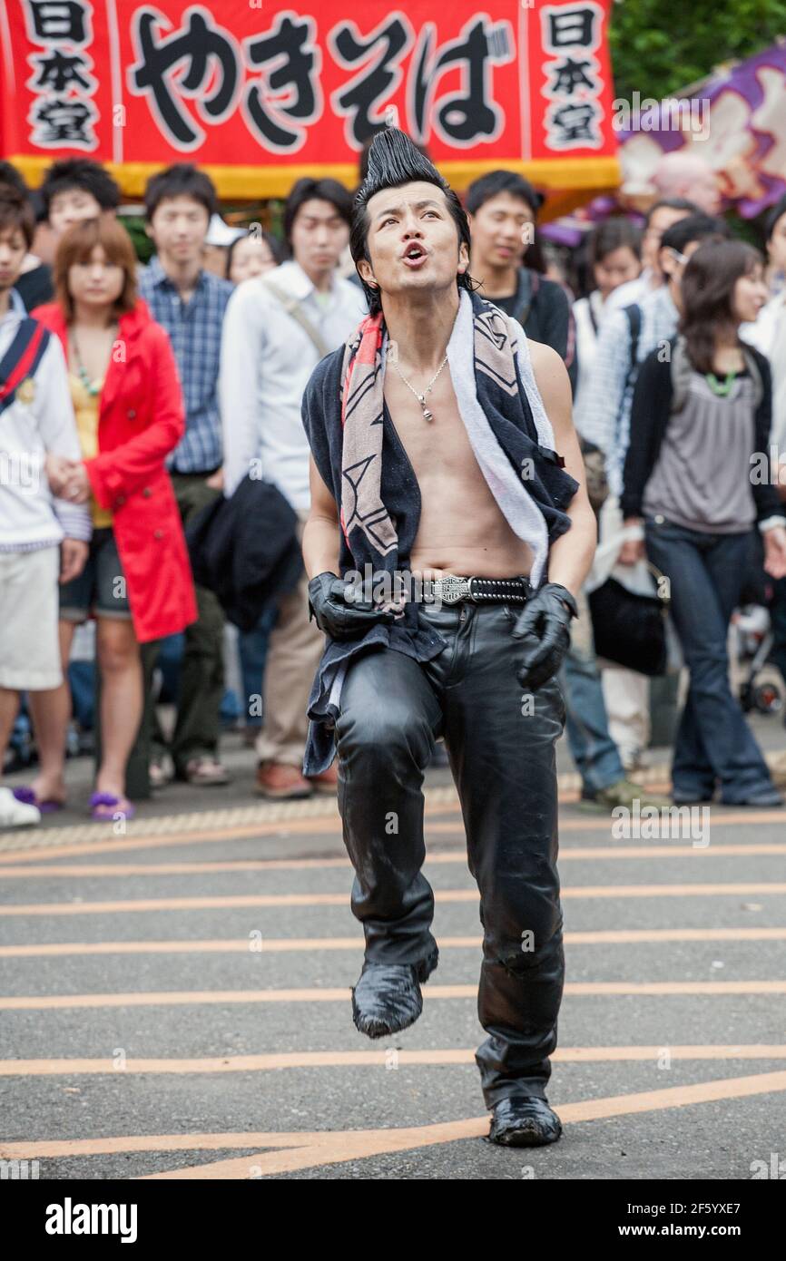Japanese Rockabillies in leather pants with quiffs dancing in front of crowd of tourists in Yoyogi Park, Harajuku, Tokyo, Japan Stock Photo