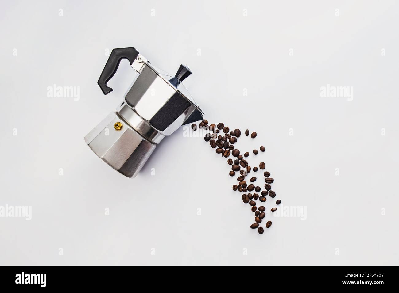 Coffee beans pouring from moka pot. Stock Photo