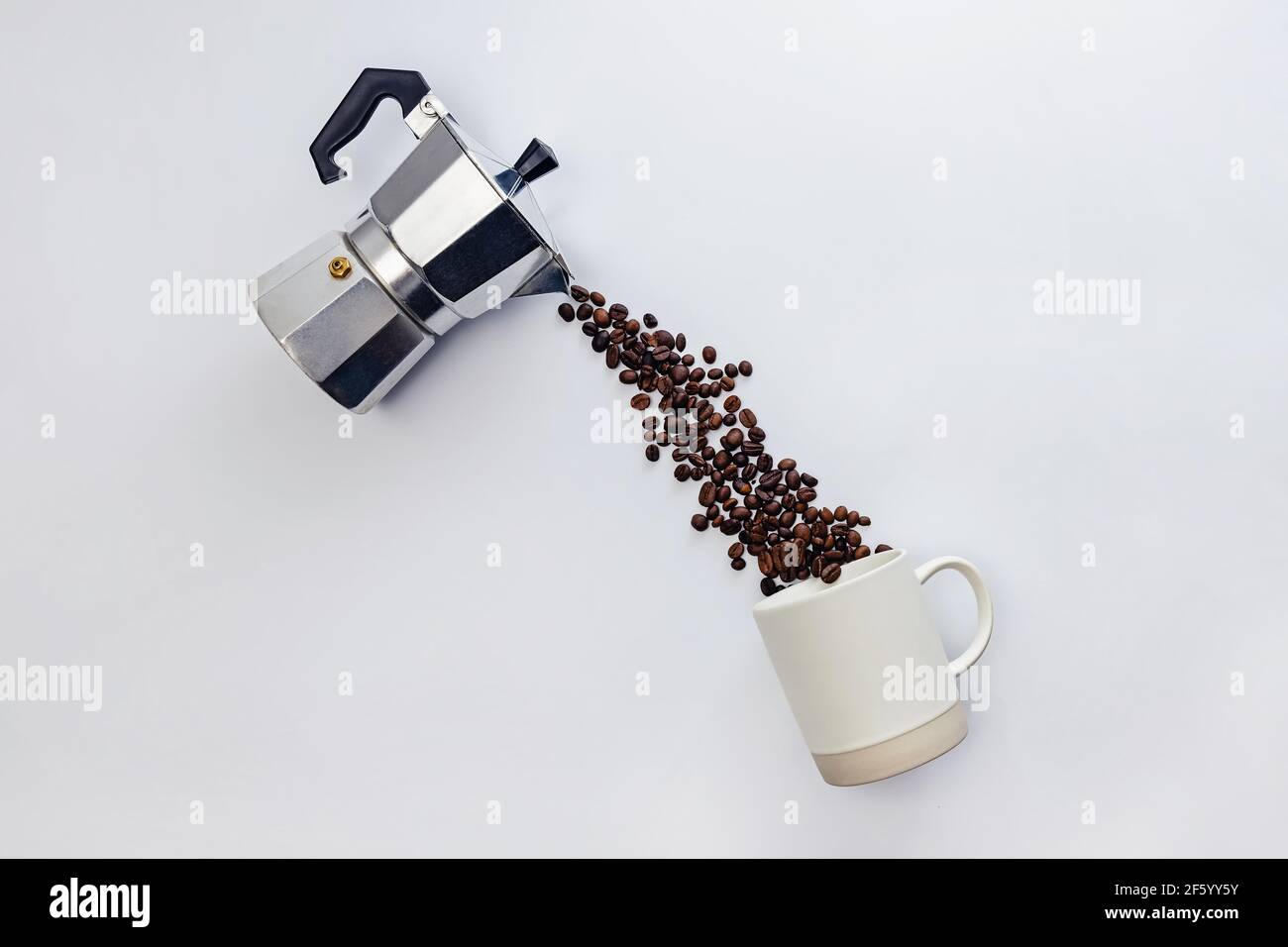 Coffee beans pouring from moka pot. Stock Photo