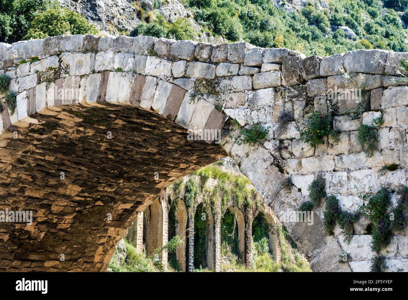 The old Mamluk stone bridge and the 17-arches Roman aqueduct in Nahr el Kalb, Lebanon Stock Photo