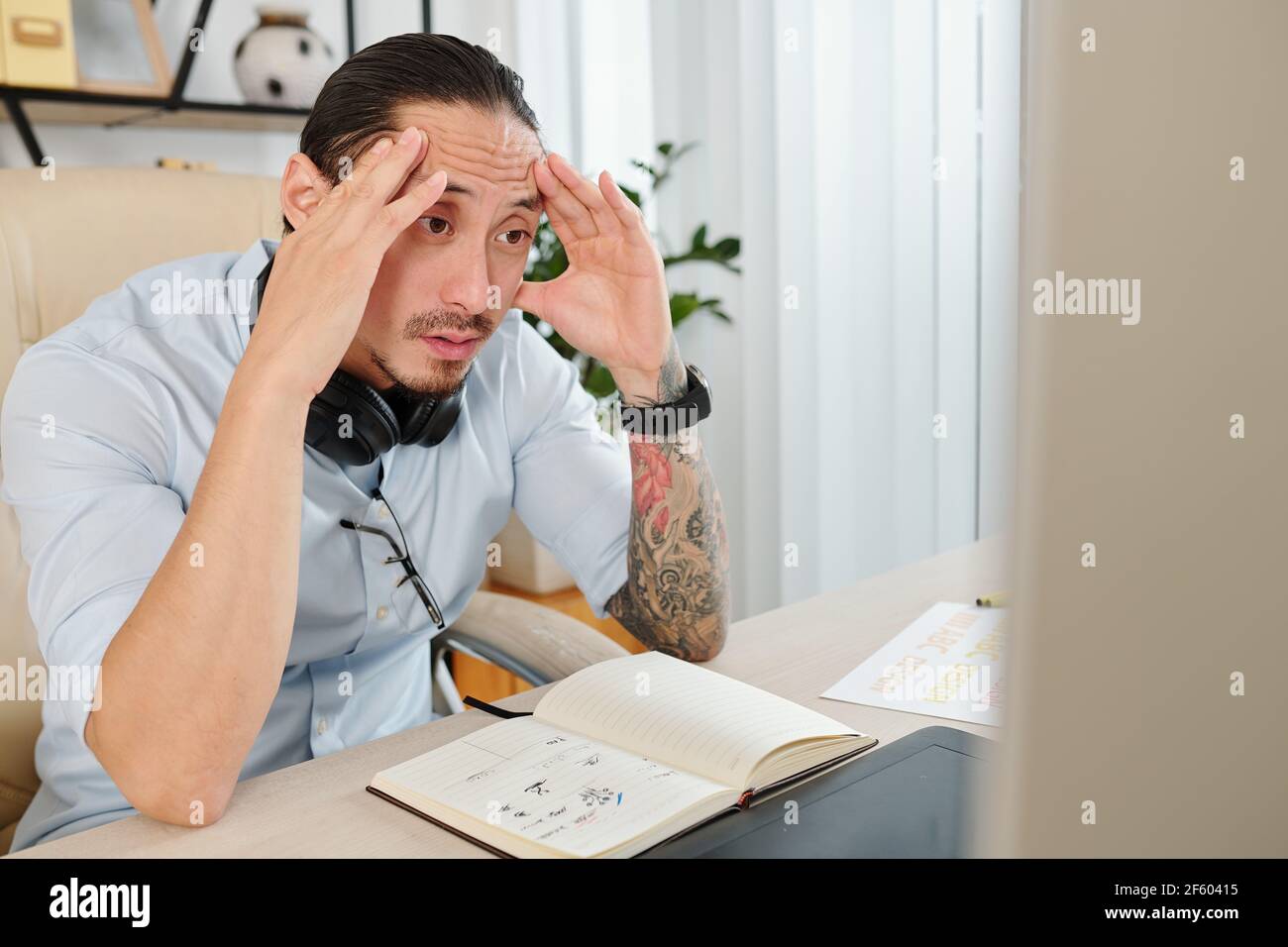 Shocked graphic designer reading confusing clients change requests on computer screen Stock Photo
