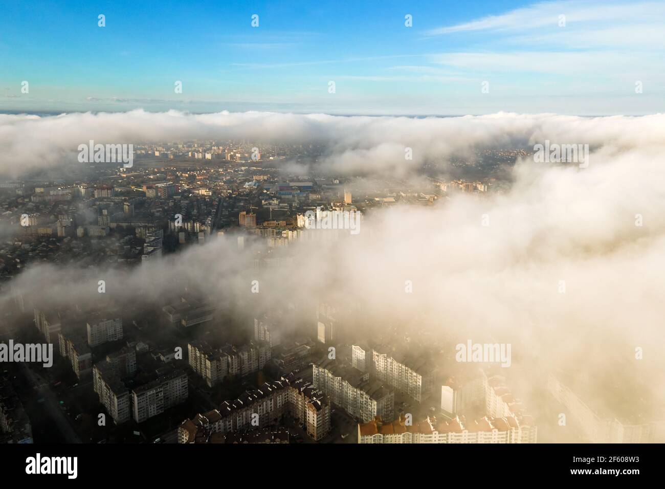 Top aerial view of fluffy white clouds over modern city with high rise ...