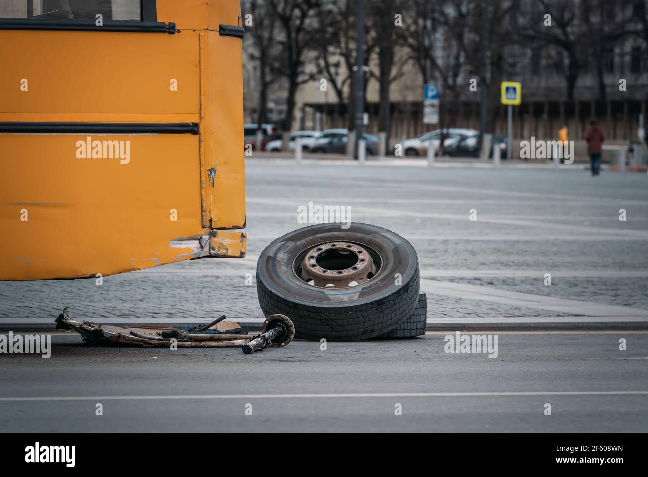 City bus with broken wheel stands on urban road. Stock Photo
