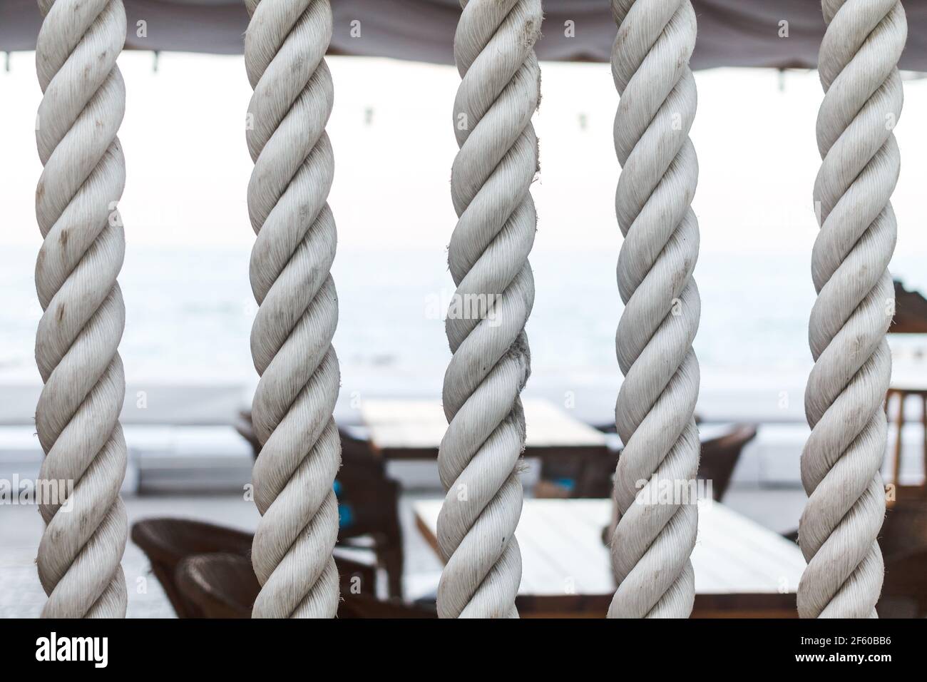 Closeup of strong string white ropes on background sea and deck