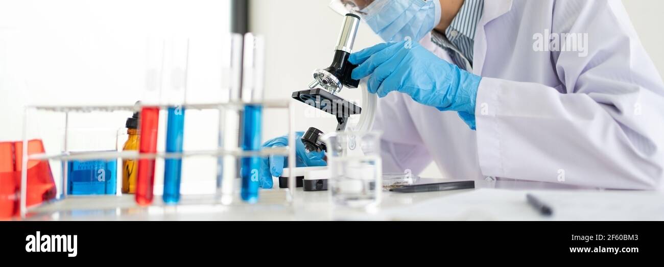 Young Asian scientist Working looking through a microscope doing ...
