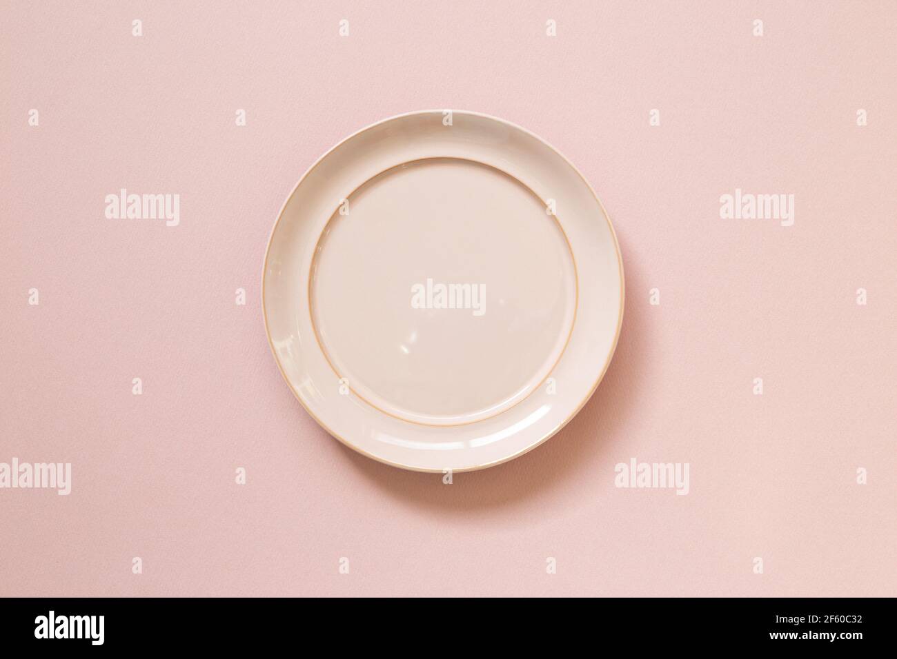 Empty ceramic round plate isolated on pink background. top view Stock Photo