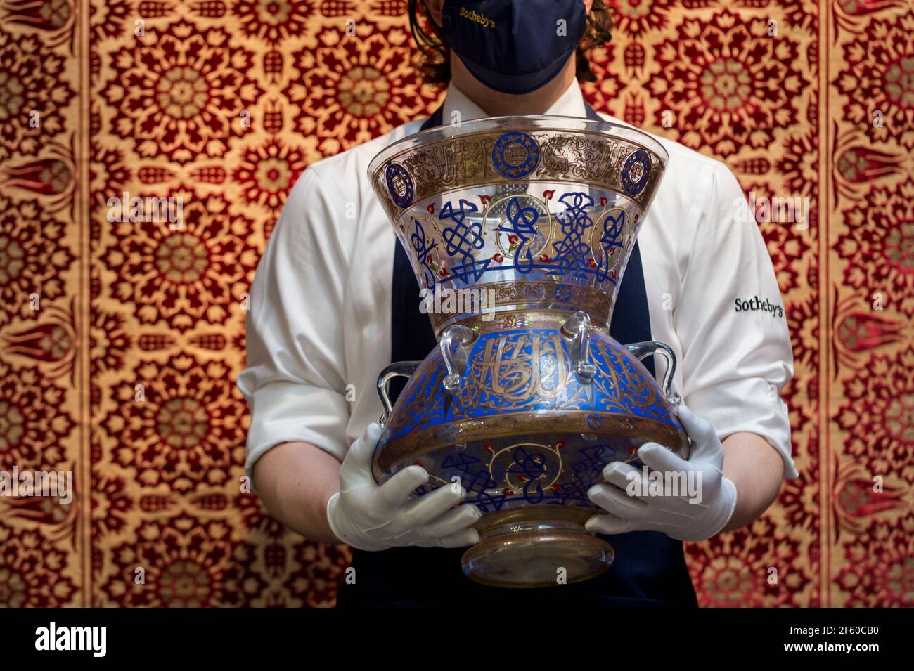 London, UK.  29 March 2021. A staff member presents 'a large mamluk revival enamelled glass mosque lamp', 20thC (est. £8,000-12000).  Preview of the upcoming Arts of the Islamic World & India sale where historic objects, paintings and manuscripts from the last 1,000 years are to be auctioned on 31 March at Sotheby’s New Bond Street galleries.    Credit: Stephen Chung / Alamy Live News Stock Photo