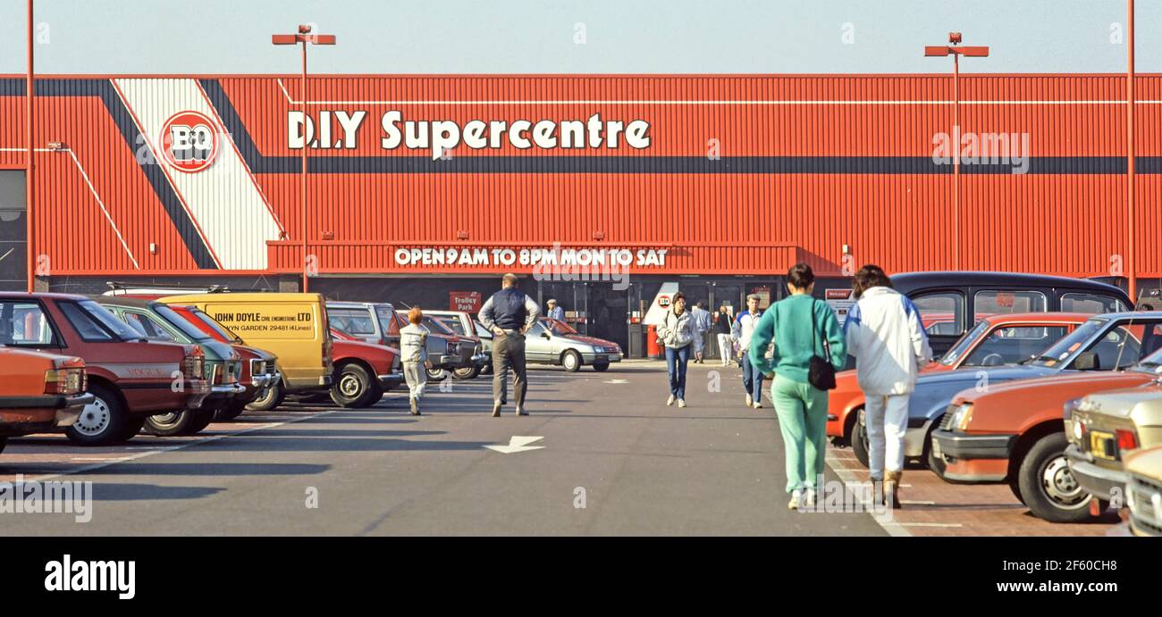 Historical archive view of 1987 early standalone version of a B&Q Do it Yourself DIY supercentre retail business store building with people in1980s shoppers car park walking to & from main entrance doors but not apparently open on a Sunday in an 80s the way we were archival image at Dagenham in East London England UK Stock Photo