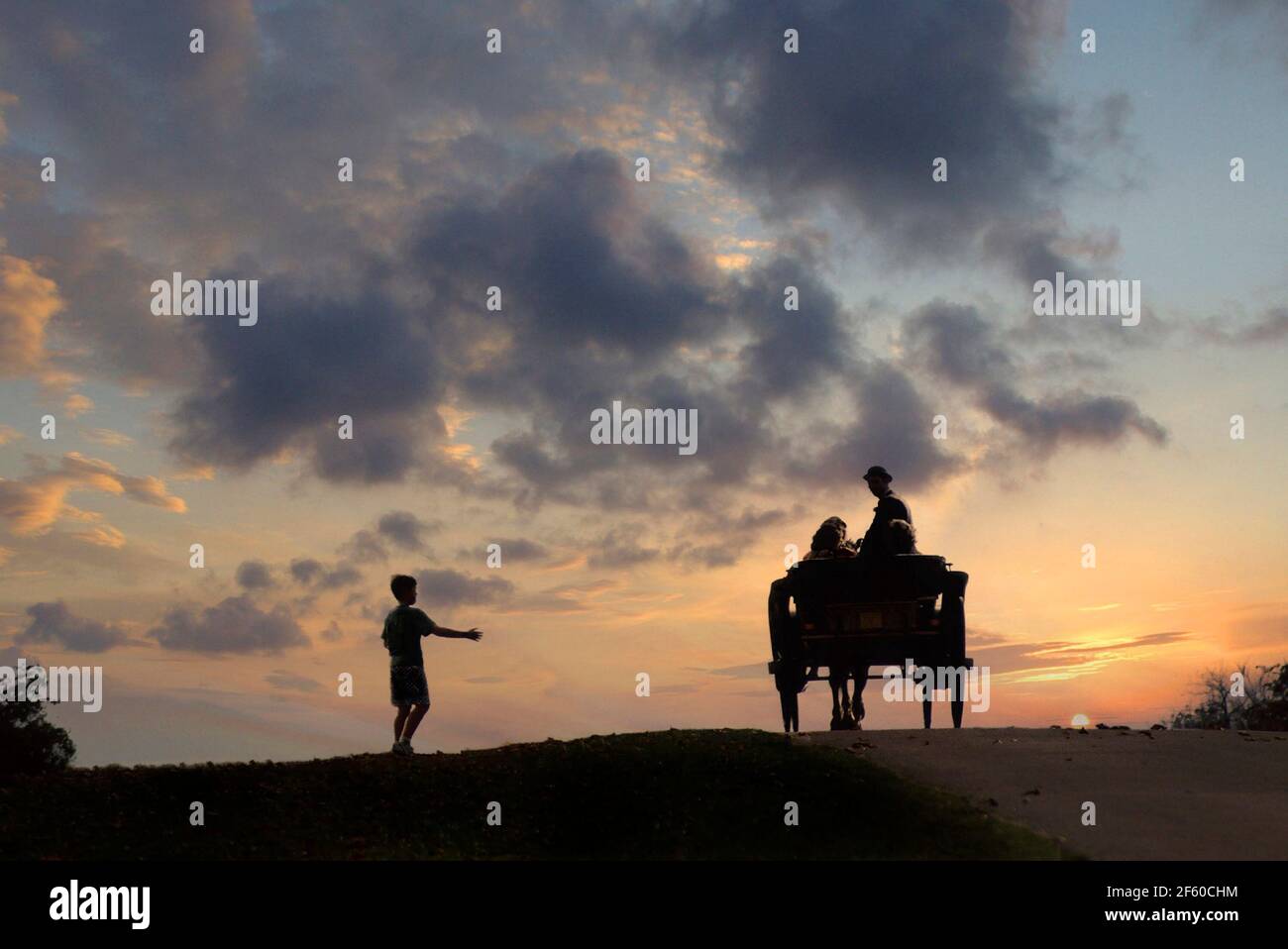 Historical archival 1989 silhouette view of people riding in 80s pony and trap on sunset skyline at brow of incline on the Long Walk in Windsor Great Park with cheeky young boy seemingly thumbing a lift in this1980s archival image in the Royal Park Berkshire England UK Stock Photo